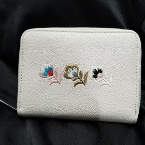 Light gray wallet with embroidered flowers.